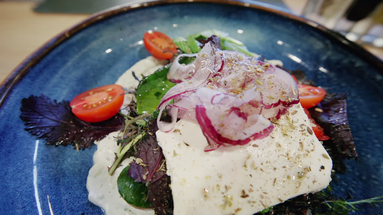 Close-up de uma salada fresca com folhas verdes, tomates e cebolas servida em um prato