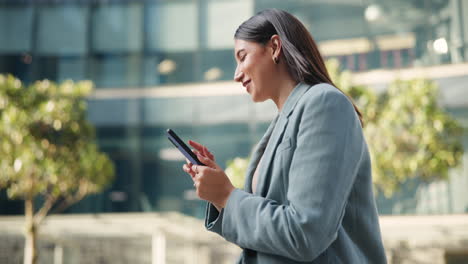 businesswoman using smartphone outside office building
