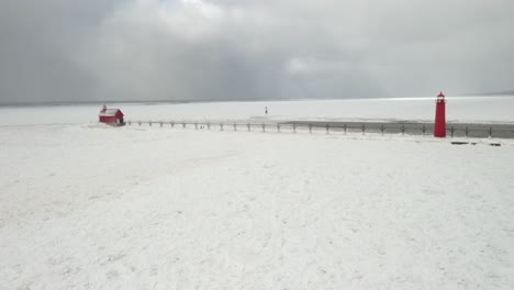 grand haven, michigan lighthouse in the winter at lake michigan with drone fly through