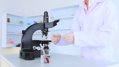 female scientist looking at a slide through a microscope