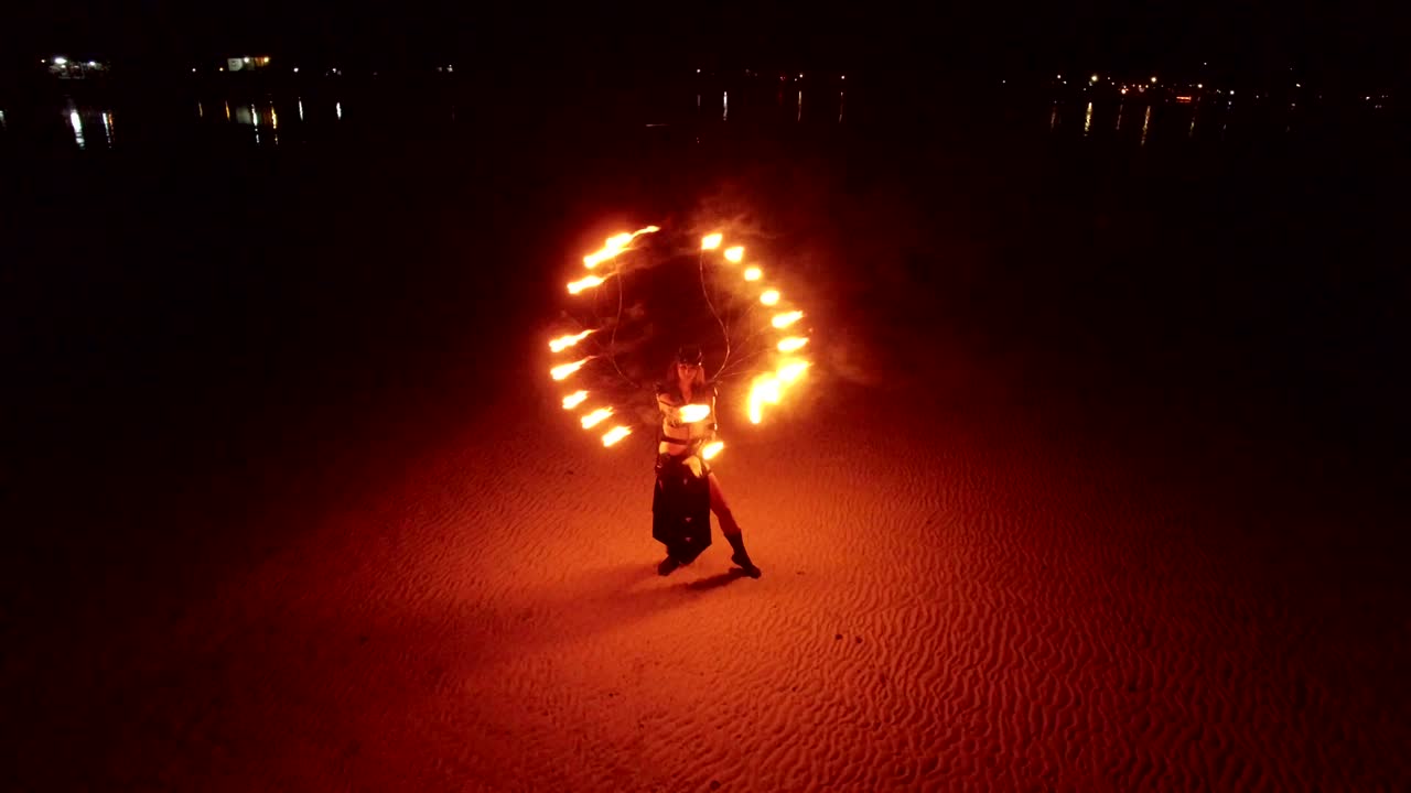 espectáculo de fuego de baile en la playa de bancos de arena al atardecer