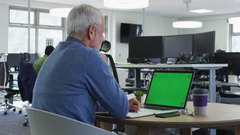 vista trasera de un hombre usando una computadora portátil en la oficina