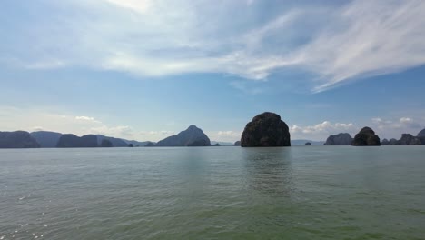 beautiful footage of a boat tour in phuket, thailand, cruising along towering limestone cliffs and tropical waters of phang nga bay, a famous travel and sightseeing destination in southeast asia