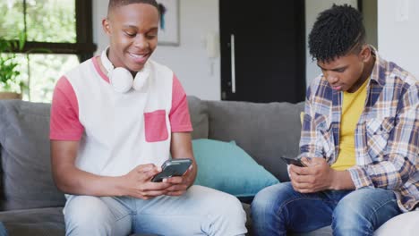 Video-of-happy-diverse-male-teenage-friends-using-smartphones,-slow-motion