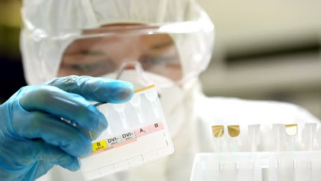 estudiante de ciencias en traje de protección comparando muestras