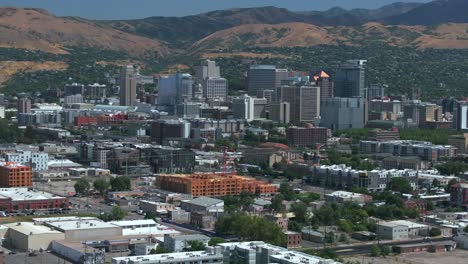 downtown salt lake city slc utah usa wasatch mountain range aerial drone forward pan up summer blue sky morning afternoon lds temple the great salt basin lake county region building traffic cars