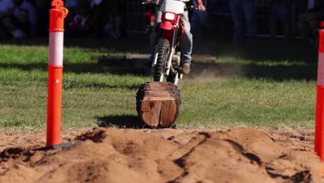 motocicleta sube y baja un obstáculo de troncos