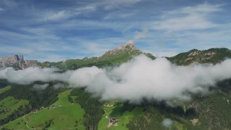 Drone-flies-smoothly-backwards,-framing-Sass-de-Putia-in-cloud-kissed-Dolomites