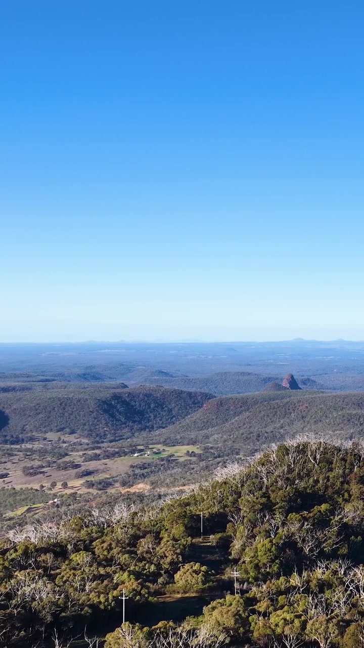 Vista panorámica amplia de cordilleras volcánicas bajo un cielo azul claro en el Parque Nacional Warrumbungle
