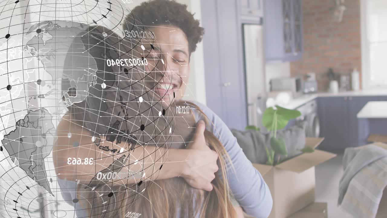 Man opening arms and hugging partner amid moving boxes in kitchen, with rotating technology globe