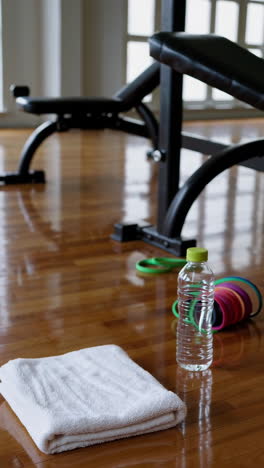 gym interior with towel, water bottle and resistance bands