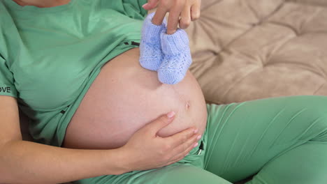 pregnant woman holding hands on belly. pregnant woman feeling happy with new life at home