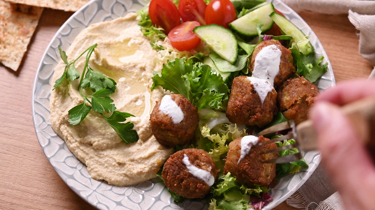Mano che prende un falafel croccante