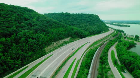 aerial view of highway and train tracks beside river