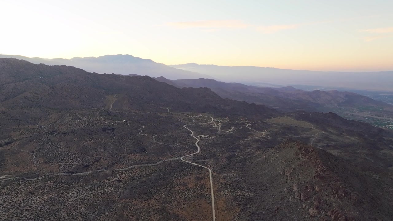 Valle desertica di Palm Springs con tortuose strade sterrate attraverso un terreno accidentato, panoramica aerea con drone