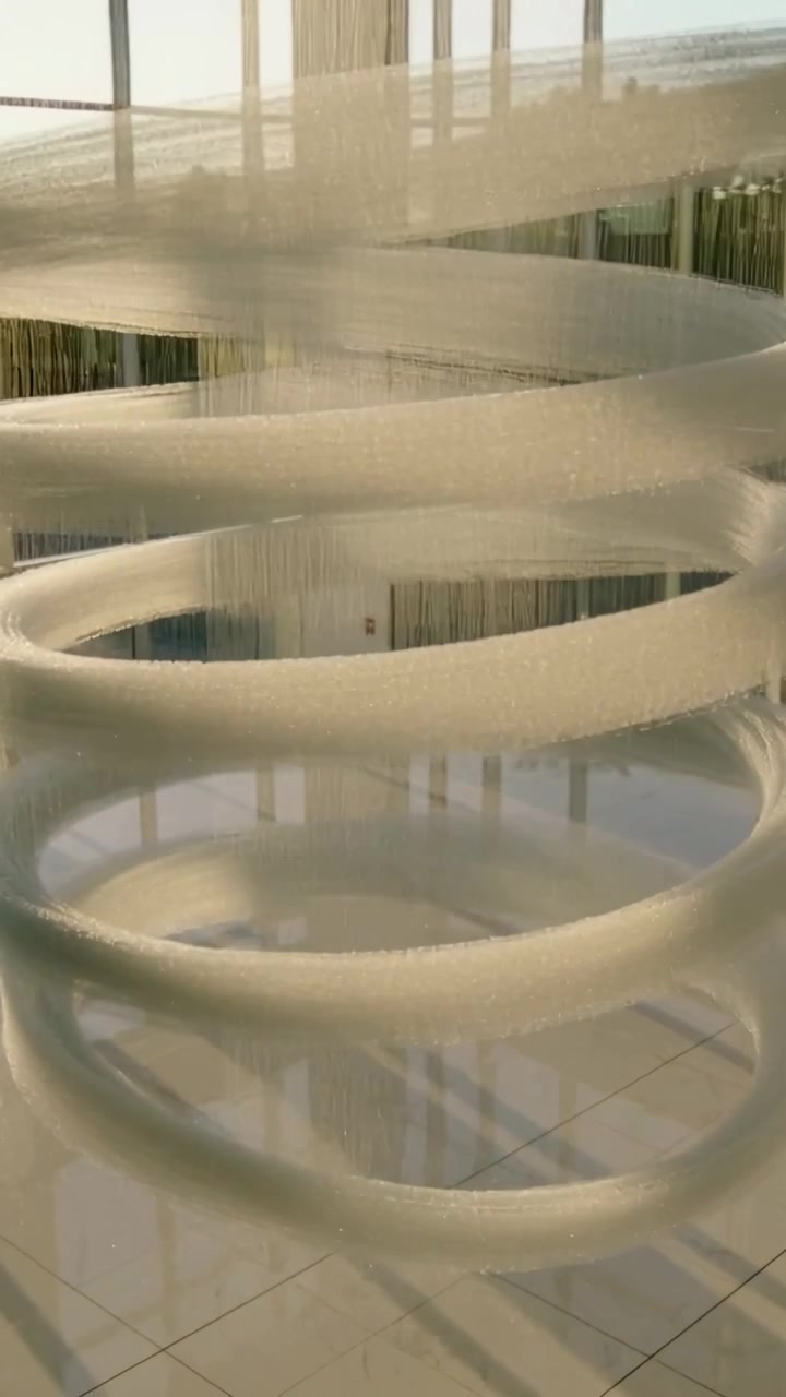 Video verticale: Telecamera che panoramica mostrando l'intera estensione di una scultura vicino alle finestre, con la luce solare che si proietta sulle piastrelle.
