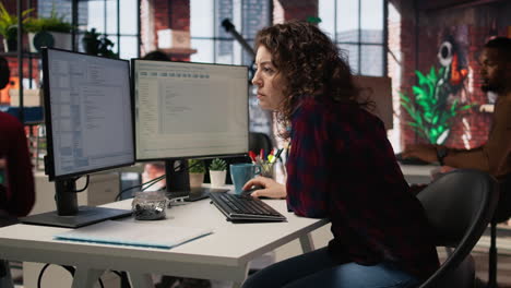 Cheerful IT expert using programming languages on PC in IT startup office