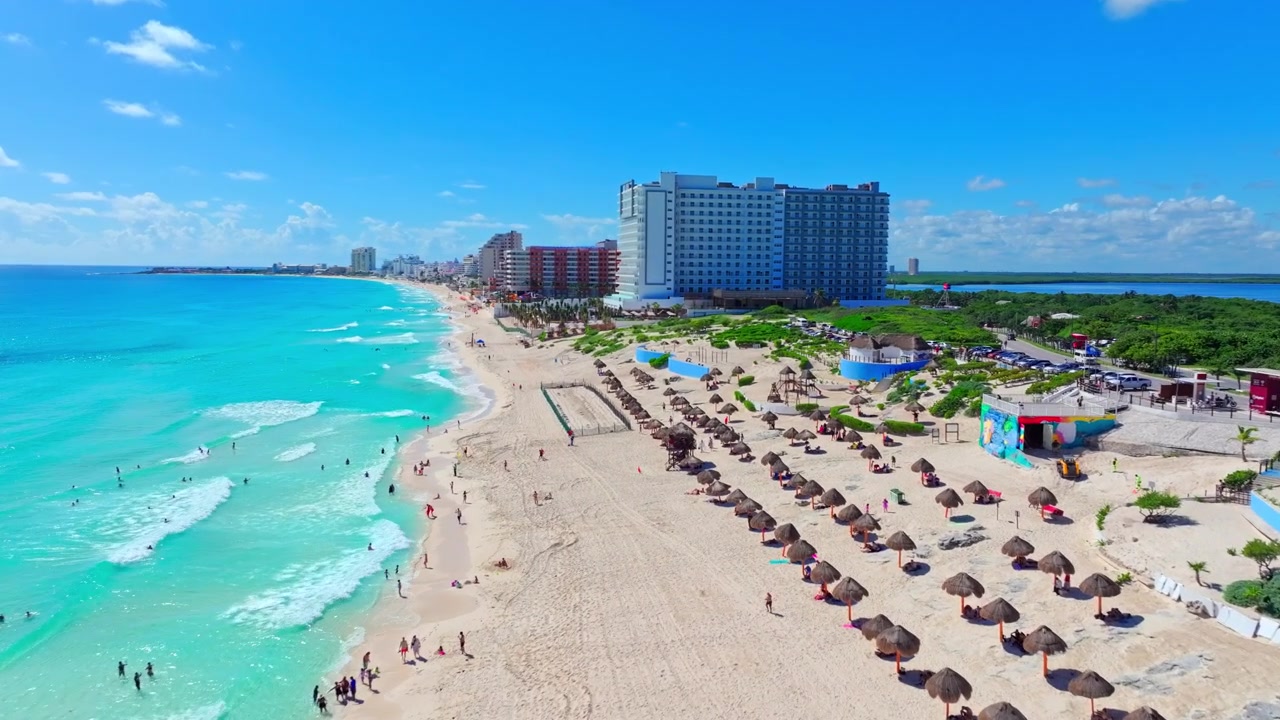 Vista aerea di una spiaggia caraibica turchese e resort nella Zona Hotelera di Cancun, Quintana Roo, Messico, sabbia bianca sotto un luminoso cielo estivo.