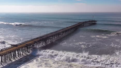 Antenne-über-Riesige-Wellen,-Die-Während-Eines-Großen-Wintersturms-über-Einen-Kalifornischen-Pier-In-Ventura-Kalifornien-Rollen,-Deutet-Auf-Eine-Globale-Erwärmung-und-Einen-Anstieg-Des-Meeresspiegels-Oder-Einen-Tsunami-Hin