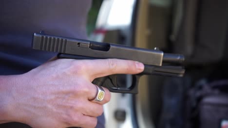 un primer plano con una cámara portátil que muestra una pistola sacada de su bolsa