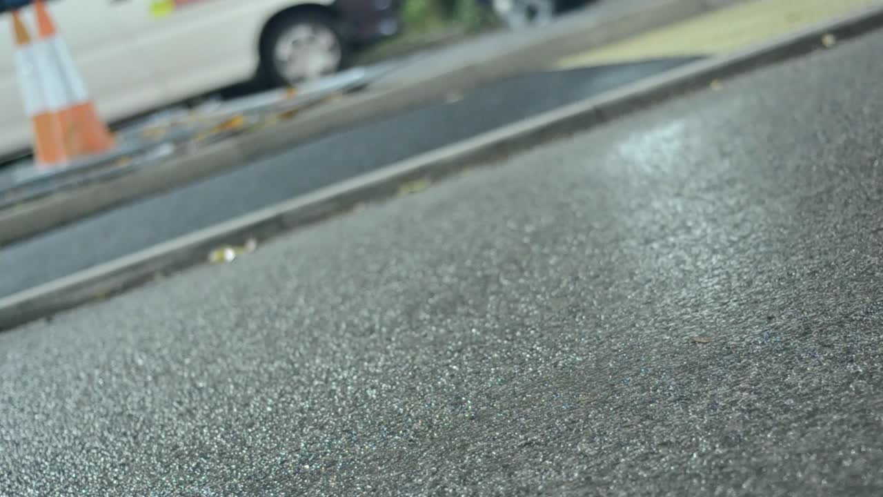 도시의 유흥 자동차 헤드라이트는 젖은 아스팔트 주차장에 반사됩니다.