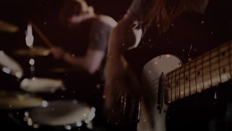 guitarist strumming electric guitar beside drummer in music studio, showing animated sound waves