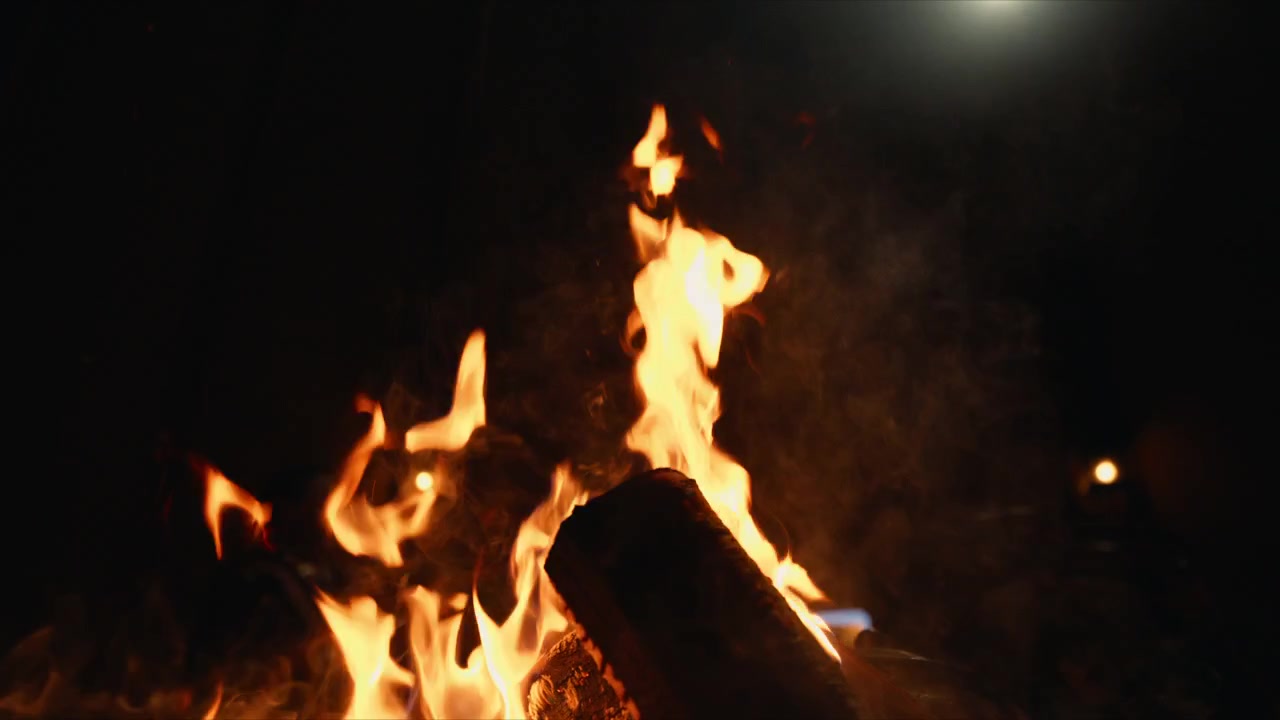 Fiamme di falò sotto una luce tremolante e brillante durante una chiara notte invernale all'aperto