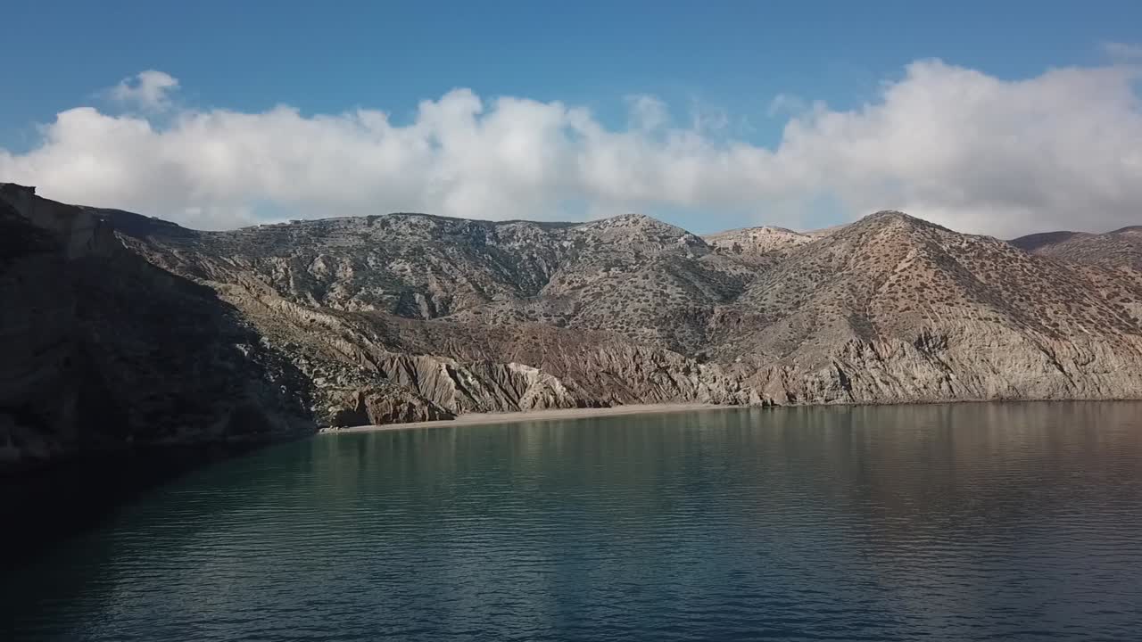 Drone shot orbiting a solitary mushroom-shaped rock pillar standing on a sedimentary plateau, showcasing unique natural erosion