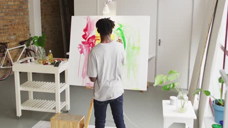 Vista-Trasera-Del-Artista-Masculino-Afroamericano-Pintando-Sobre-Lienzo-En-El-Estudio-De-Arte.