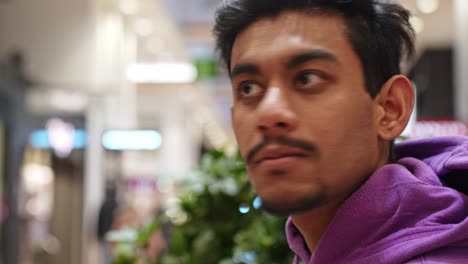 Powerful-man-with-moustache-sitting-in-shopping-mall-and-look-around