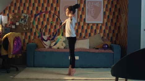 young girl dances with gymnastic ribbon young asian girl dances with gymnastic ribbon showing legsplit and spins around herself gymnastics training sports hobby upgrading physical health on quarantine slow motion