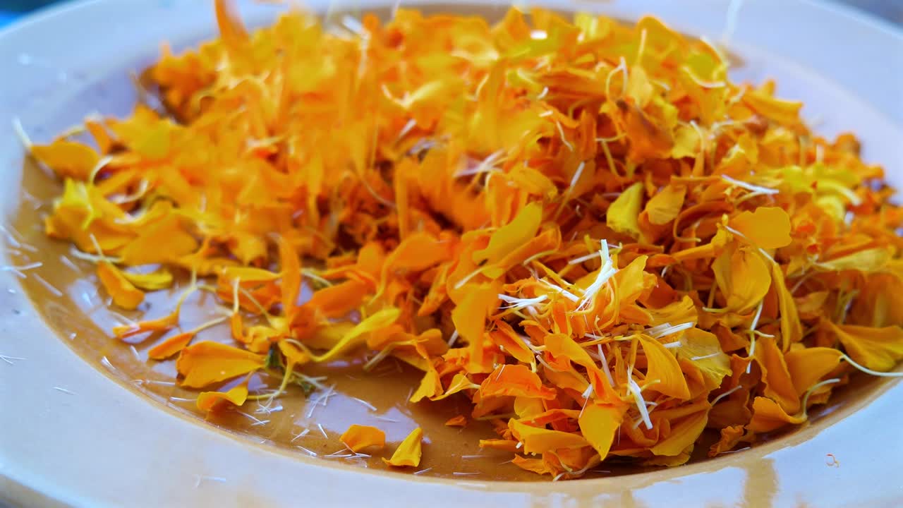 Human hand sifting through marigold petals