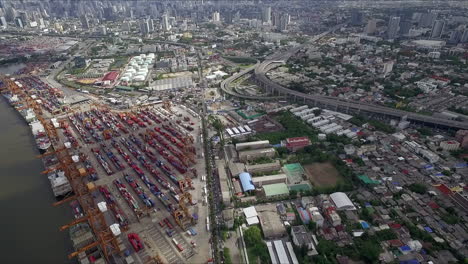 Logistic-concept-aerial-shot-of-commercial-maritime-transport-dockyard-with-cargo-ships-waiting-to-be-upload---offload-cargo-containers