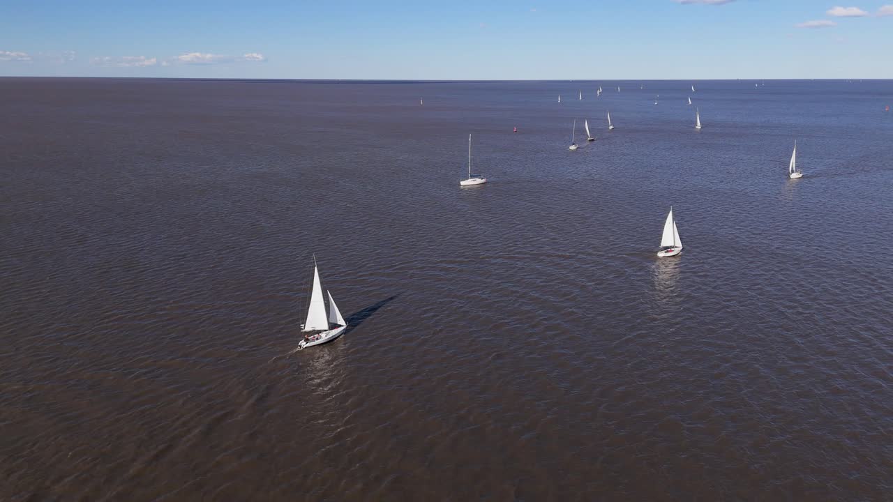 Boats sail on Rio De La Plata, capturing serene windsurfing vibe