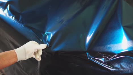 applying a blue vinyl wrap to a car