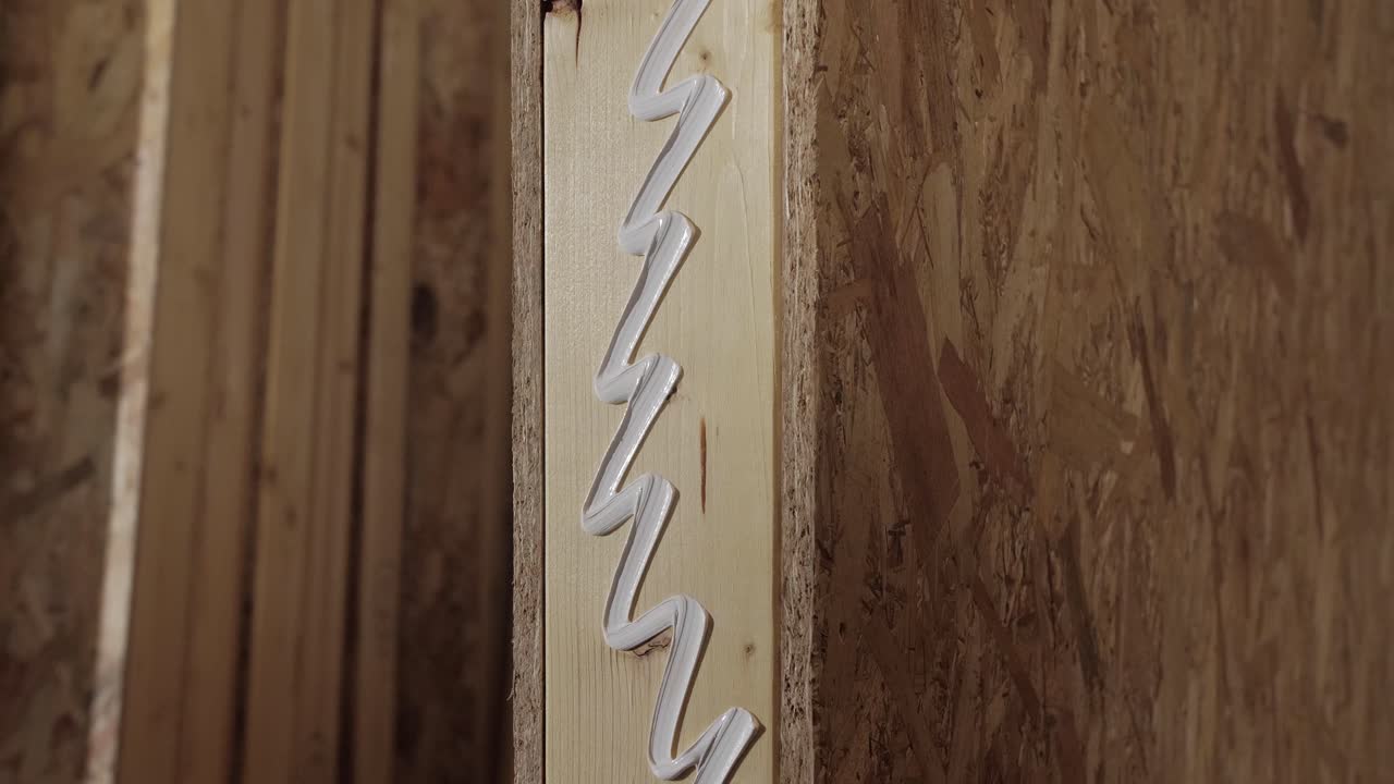 Applying Adhesive to Wood Panel During Construction