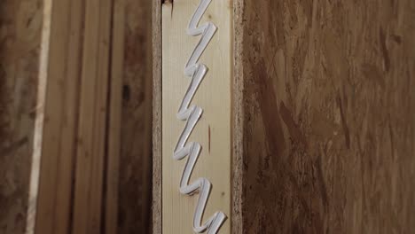 applying adhesive to wood panel during construction