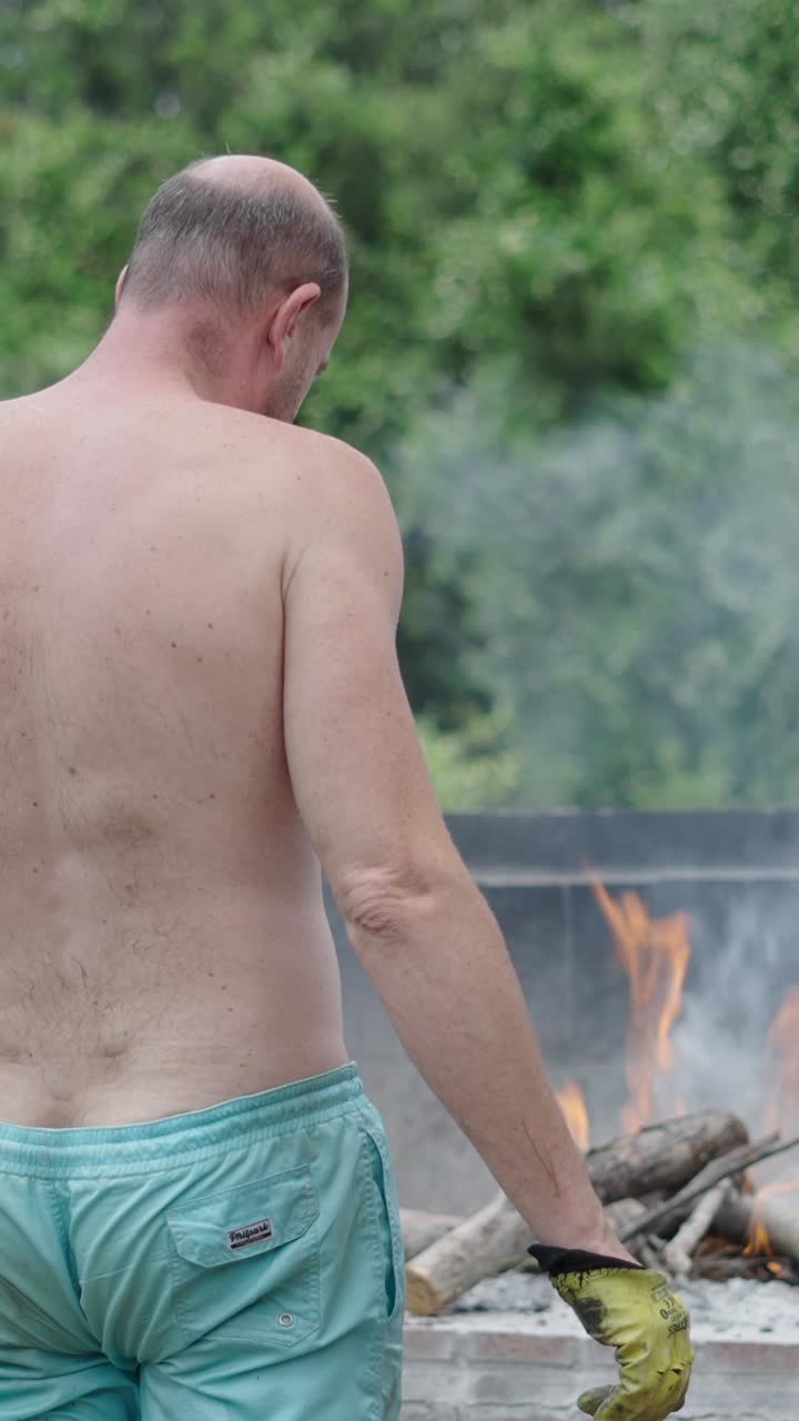 Man tending a fire outdoors