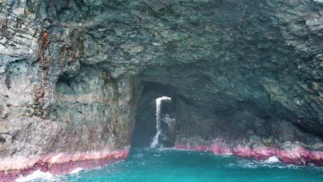 HD-Hawaii-Kauai-Boating-on-the-ocean-wide-shot-truck-in-approaching-waterfall-in-ocean-cave