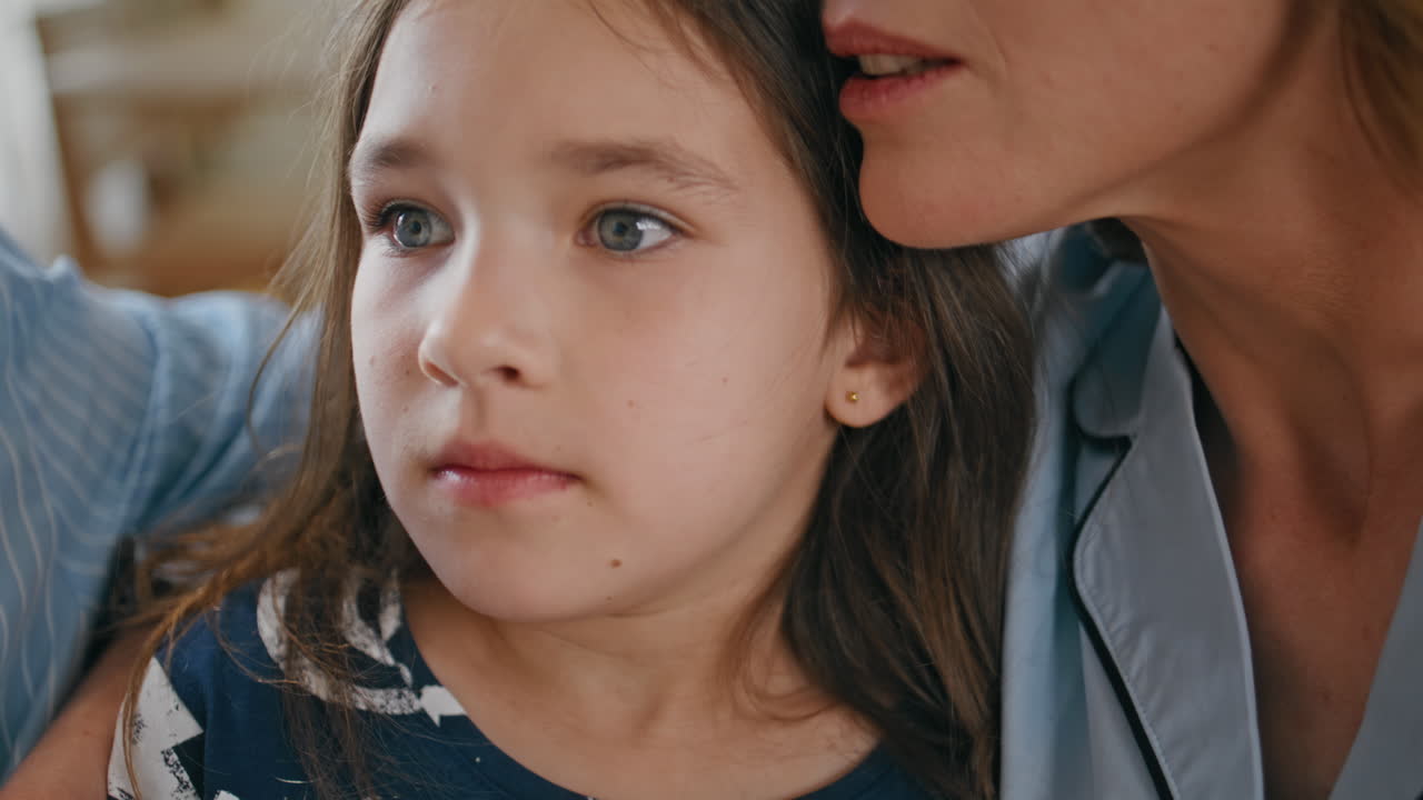 Scared child watching cinema at home together with parents closeup. Little girl