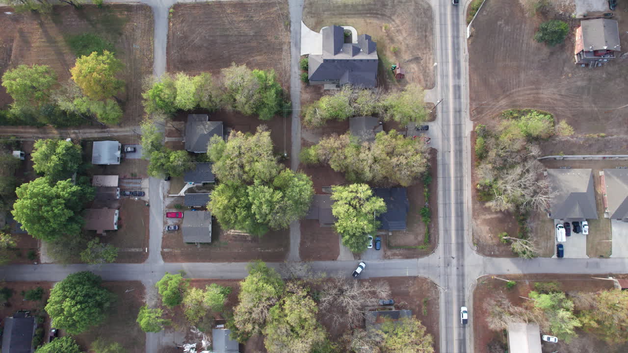 cars drive through a small town in the midwest, USA, normal small town neighborhood, top down drone