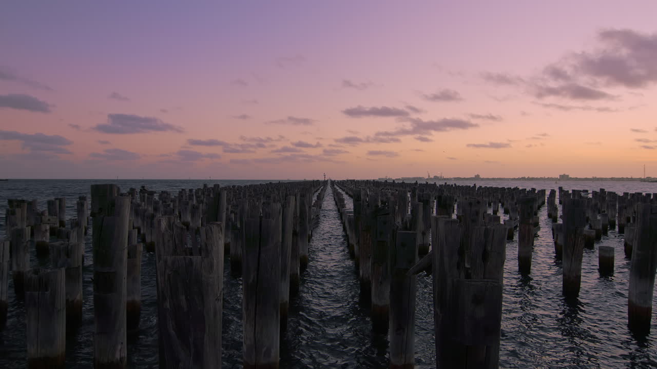 hermosa puesta de sol en los pilones de madera de princess pier con nubes que se mueven lentamente en el cielo