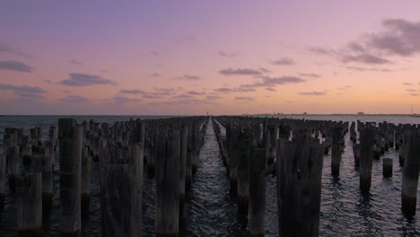 Hermosa-Puesta-De-Sol-En-Los-Pilones-De-Madera-De-Princess-Pier-Con-Nubes-Que-Se-Mueven-Lentamente-En-El-Cielo