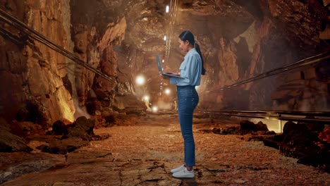Full Body Side View Of Asian Female With Her Laptop In Underground Mine Tunnel, Typing And Dissapionted With Nodding Her Shead