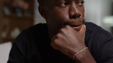 close up of unhappy and depressed young man sitting on sofa at home messaging or browsing on mobile phone 2