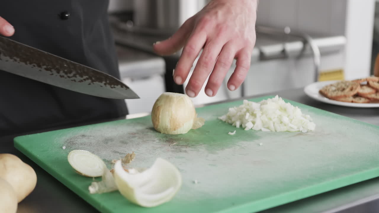 chef caucásico cortando verduras en la cocina, en cámara lenta