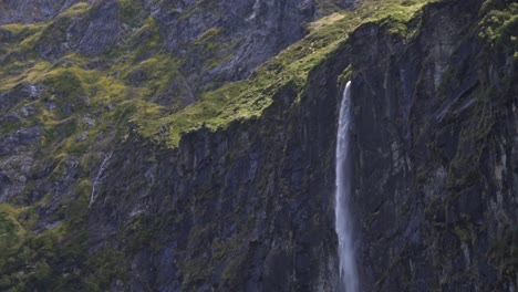 Close-up-view-of-a-waterfall-rushing-out-a-a-steep-rock-wall