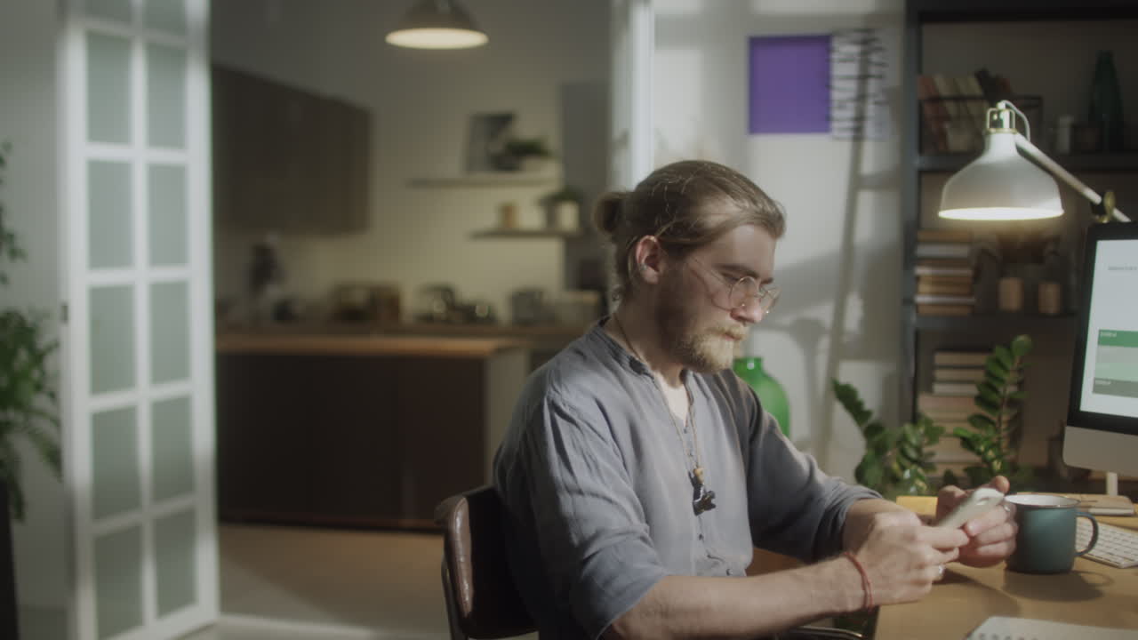 Male Designer Using Phone at Home Workplace