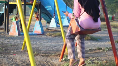 alguien jugando al swing solo en el patio de recreo de los niños durante el estado de emergencia por la razón de la amenaza del virus covid-19