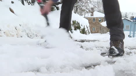 person shoveling snow on a snowy street